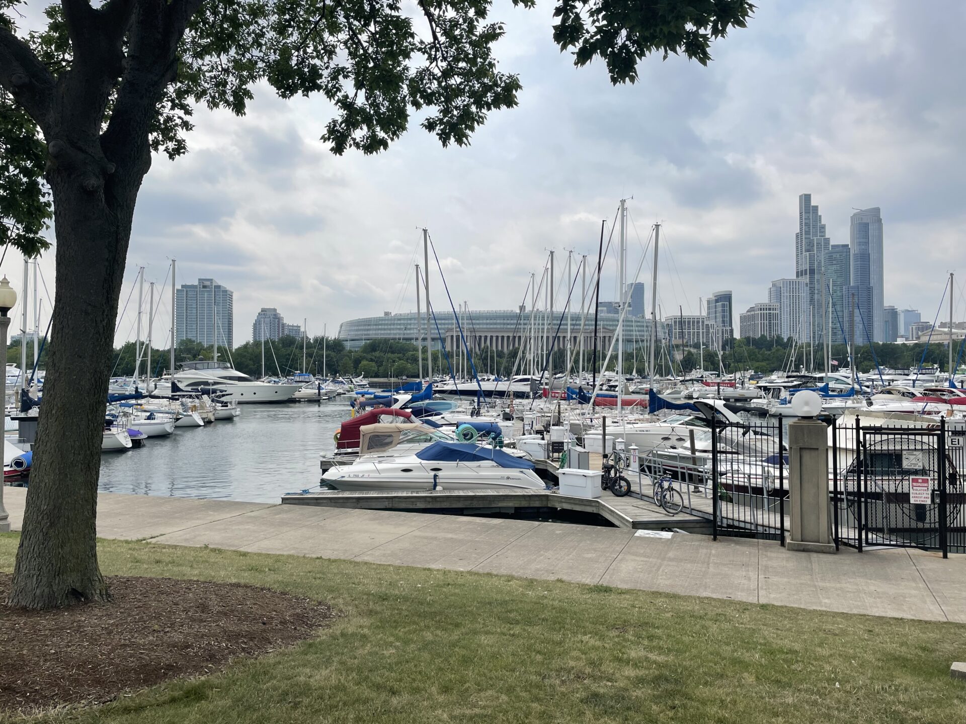 Sailboats and motorboats docked near Northerly Island, with Soldier Field and Chicago high-rises in the background.