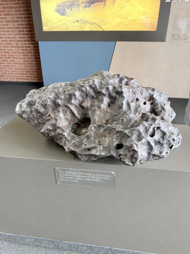 Large metallic meteorite fragment with a heavily pitted surface on display at Meteor Crater in Arizona.