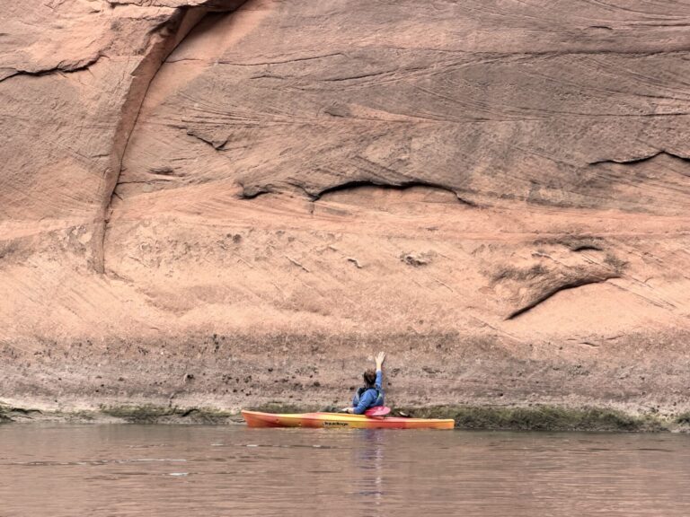 Stephanie paddling along the sandstone cliffs of the Colorado River in Glen Canyon, Arizona