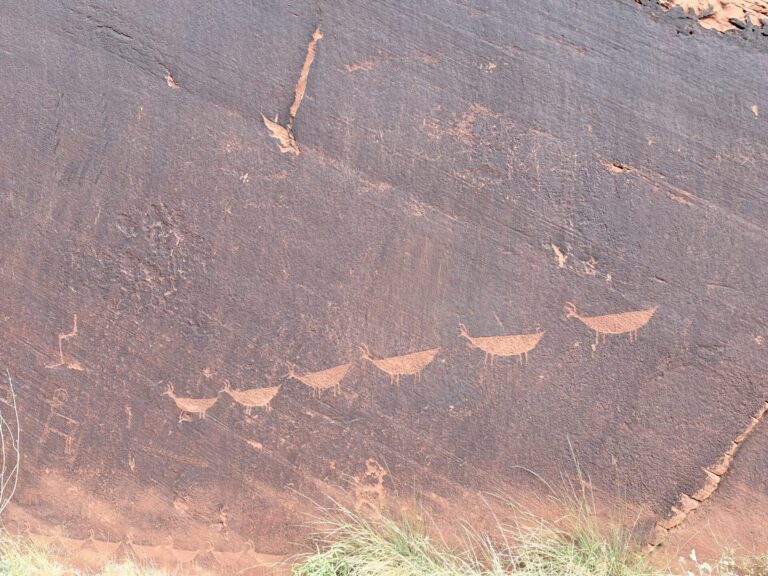 Ancient petroglyphs carved into a sandstone cliff along the Colorado River in Glen Canyon, Arizona.
